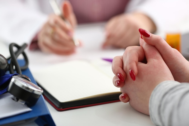 Hands of woman patient for medical report written by doctor health condition