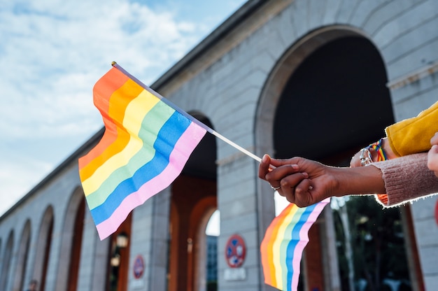 The hands of women with a gay pride flag