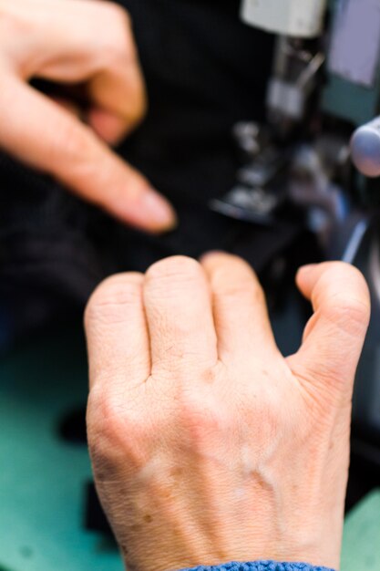 Hands work a sewing machine.