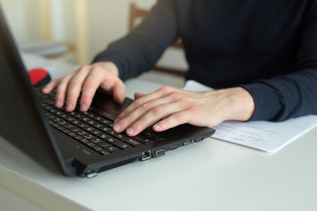 hands of a working man behind a laptop