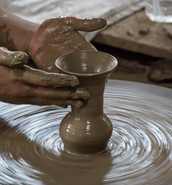 Hands working on pottery wheel