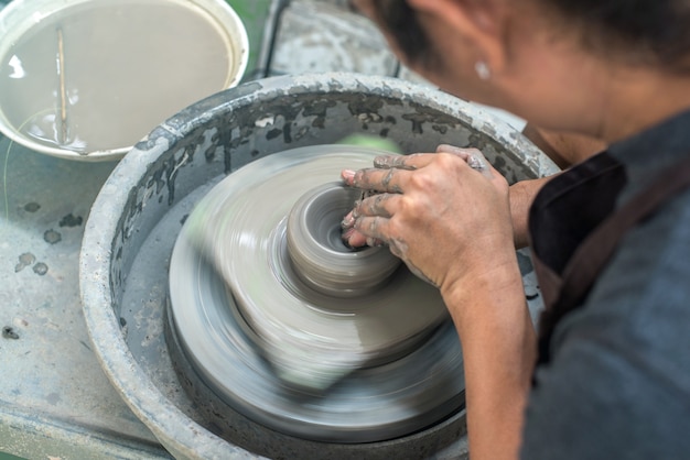 Hands working on pottery wheel