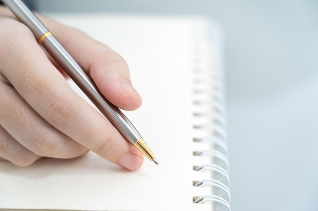 Hands working writing notebook on desk