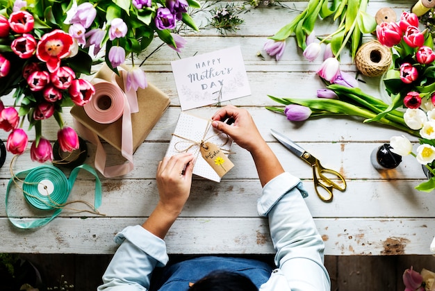 Foto mani che avvolgono un regalo per la festa della mamma