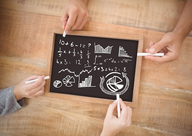 hands writing equations on blackboard