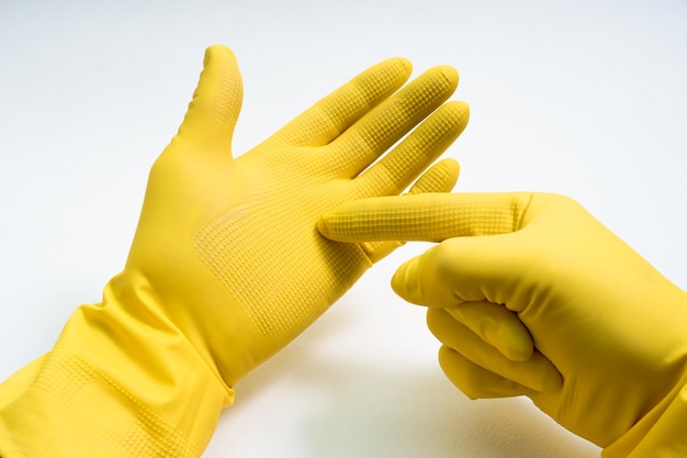 Photo hands in yellow rubber gloves on white background