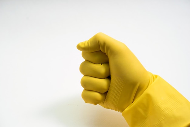 白い背景の上の黄色のゴム手袋の手