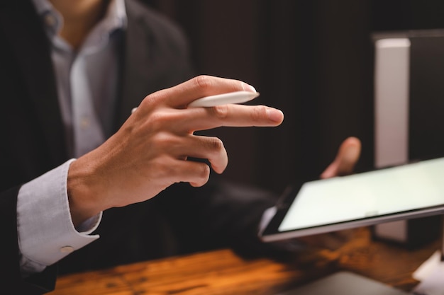 Hands of young business man holding digital pen while reading and looking at document