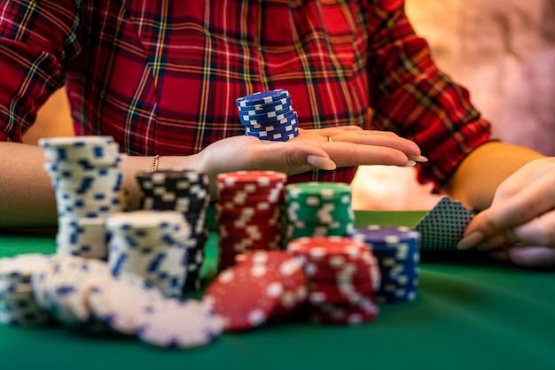 カジノ テーブルのクローズ アップで美しいマニキュアを持つ若い白人女性の手