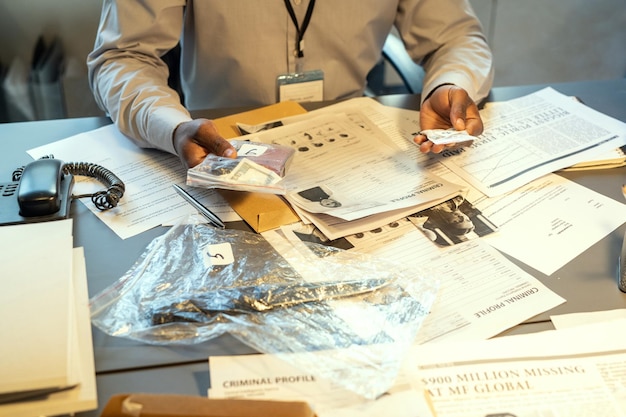 Hands of young contemporary fbi agent or detective holding evidences