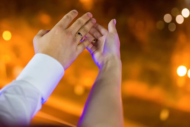 Photo hands of young couple are holding hands on the background of the night city