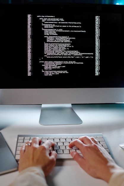 Hands of young female programmer typing on keyboard while decoding data