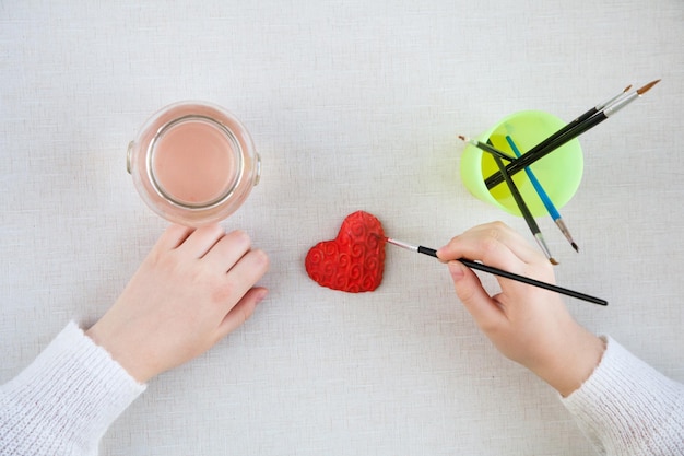 hands of a young girl painted handmade gift in the form of Heart