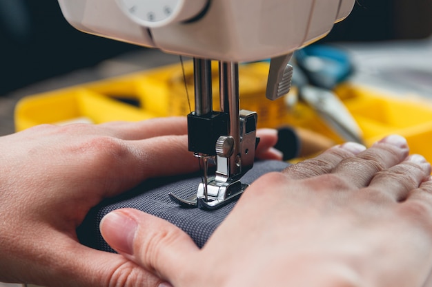 Hands of young girl on sewing machine