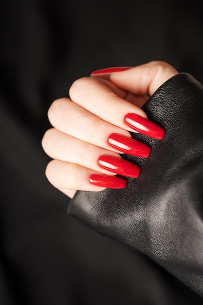 Hands of a young girl with red manicure on nails