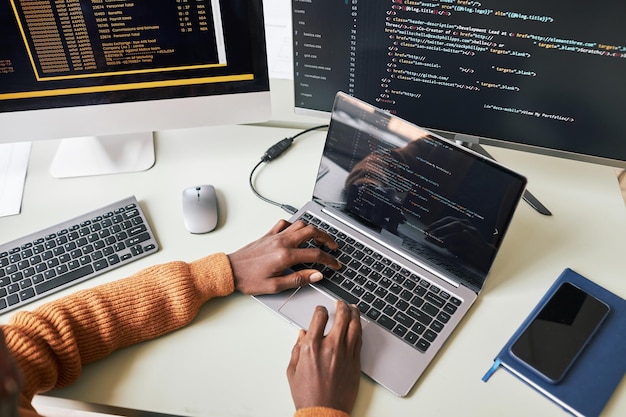 Hands of young man testing programming code for new application
on laptop