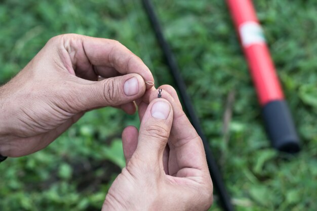 Hands of a young man who makes fishing gear