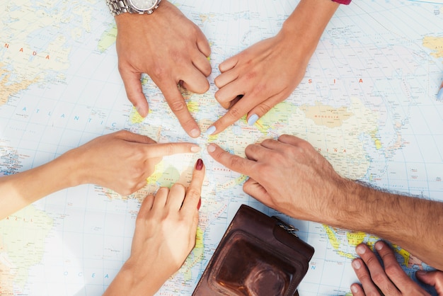 Hands of Young People are Pointing to Travel Map.