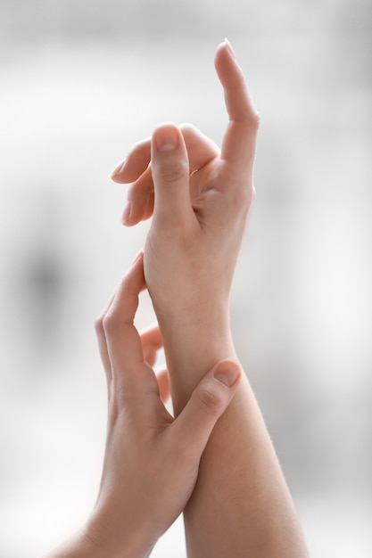 Foto mani della giovane donna che applica la crema a casa