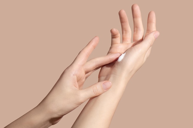 Hands of a young woman applying the cream Skincare concept