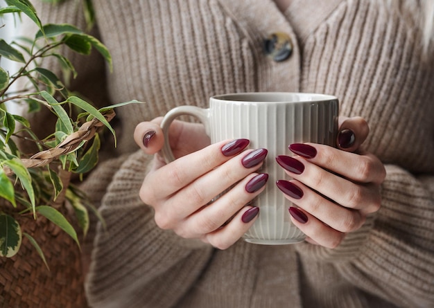 Mani di una giovane donna con il manicure bianco sulle unghie