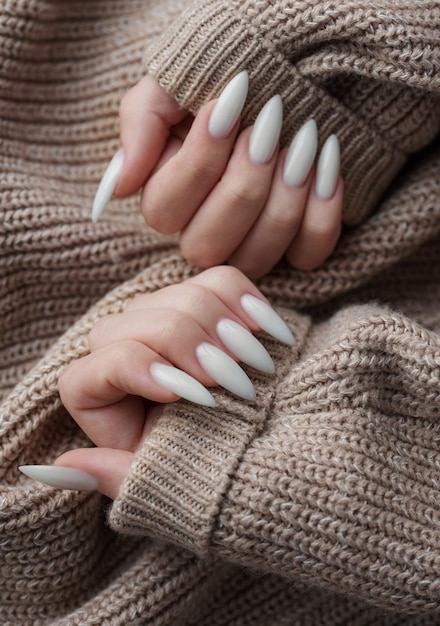 Hands of a young woman with white manicure on nails