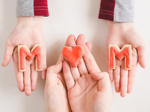 Hands of a younger daughter and her mother's