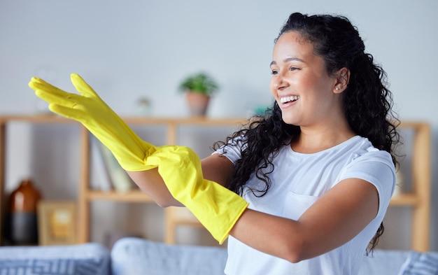 Handschoenen en hygiëne schoonmaken met een zwarte schoonmaakster in haar huis voor het huishouden of klusjes Handenbacteriën en gezondheid met een gelukkige jonge vrouw in een huis dat werkt als huishoudster