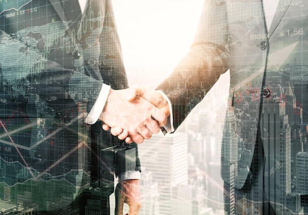 Handshake on abstract city background with forex chart Teamwork and management concept Double exposure