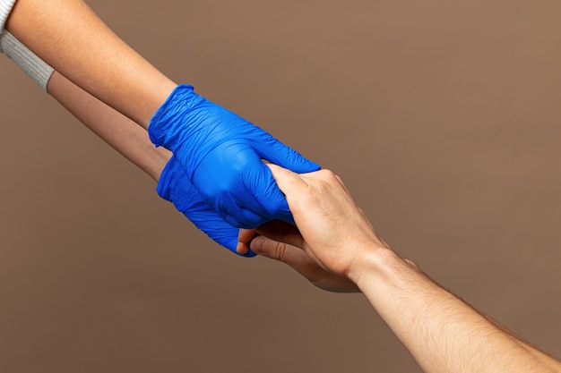 Handshake in a blue gloves, help concept. Personal hygiene during a pandemic