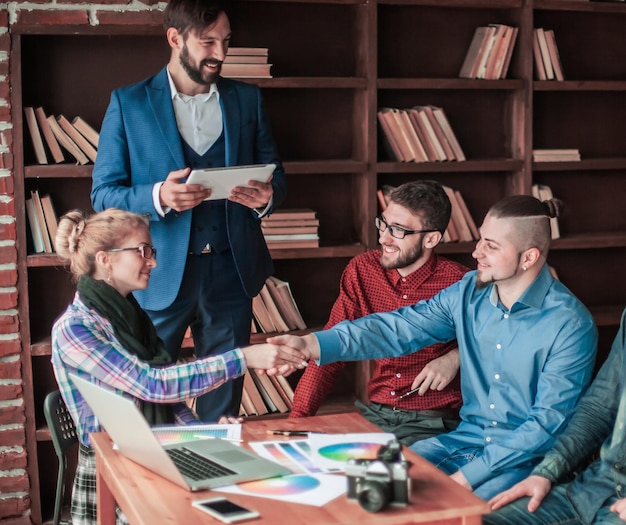 Handshake business partners at a meeting in creative office