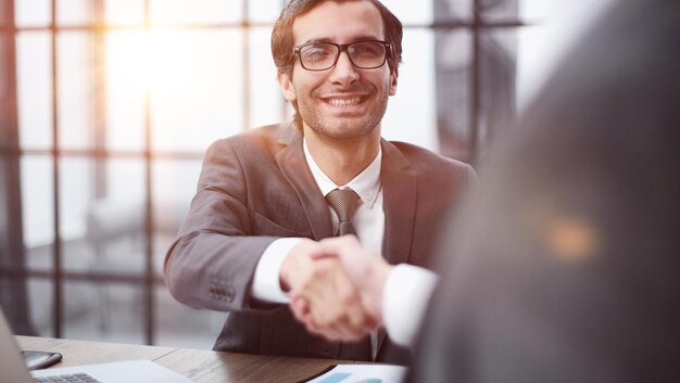 Foto stretta di mano dei partner commerciali durante una riunione in ufficio