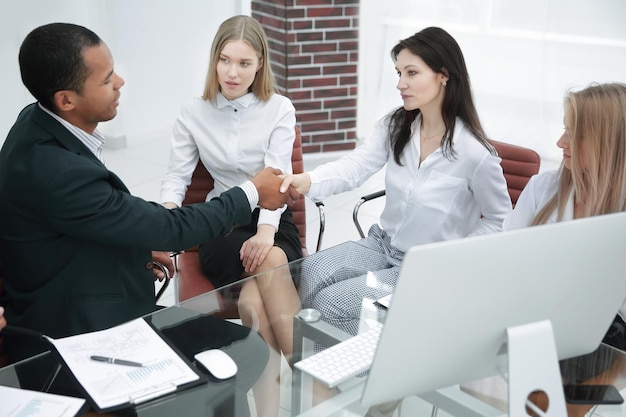 Foto stretta di mano dei partner commerciali in un ufficio moderno