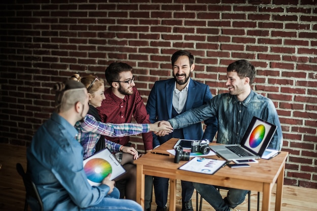 Partner commerciali della stretta di mano sul posto di lavoro in un ufficio moderno.