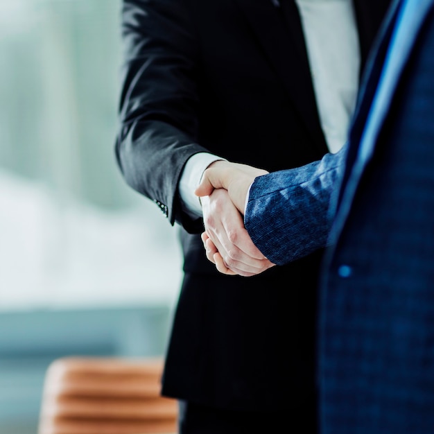 Handshake of business partners on the  of the workplace