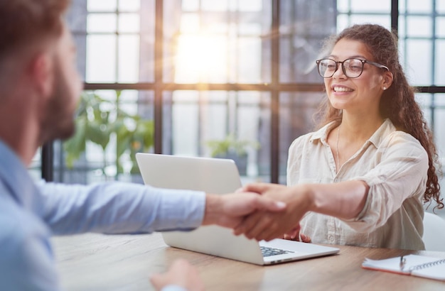 Handshake of business people sitting at the table in the office