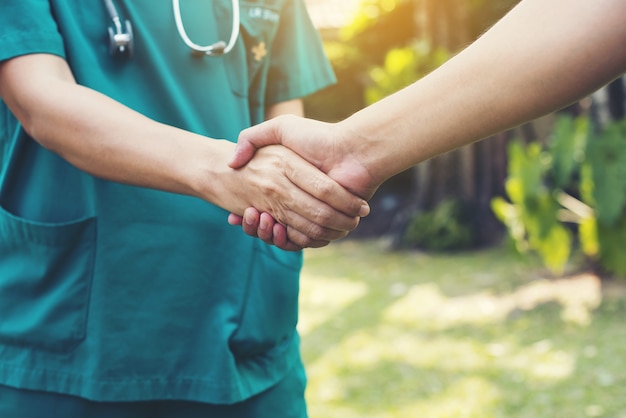 handshake between doctor green cloth and patient