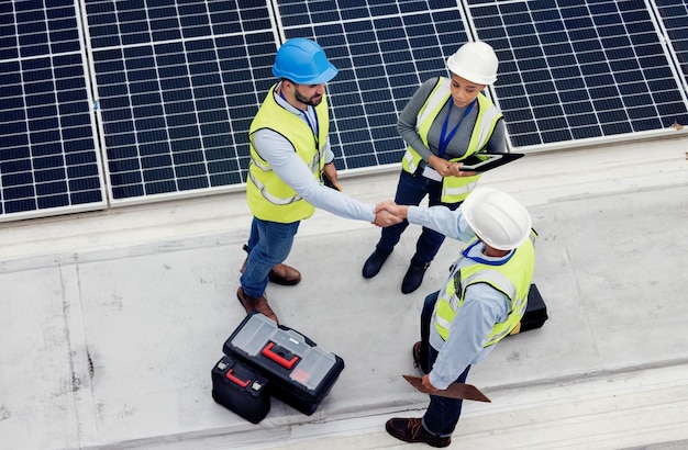 Handshake engineering en team dat werkt aan zonnepanelen voor inspectie, onderhoud of installatie