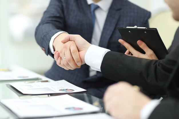 Handshake of financial partners at the Desk