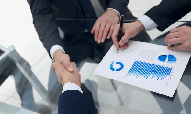 Handshake of financial partners at the desk