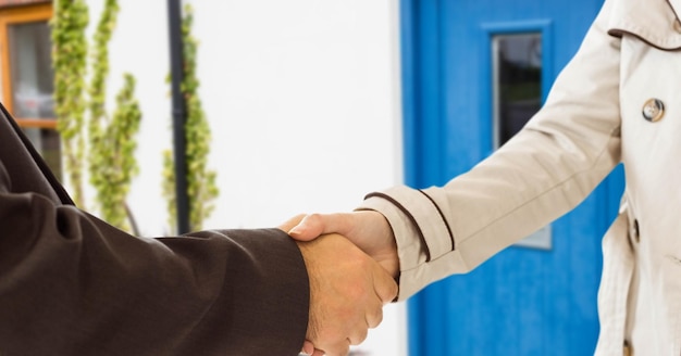 handshake in front of the door of the house