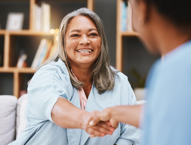 Foto handshake gezondheidszorg en afspraak met een oudere vrouw die de hand schudt met een vrouwelijke verpleegster in een bejaardentehuis bedankt medisch en ontmoeting met een volwassen patiënt en medicijnprofessional