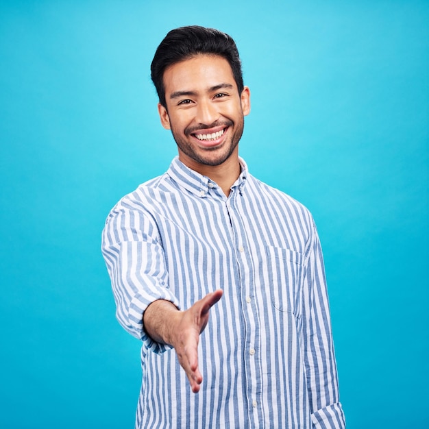 Handshake interview and portrait of business man on blue background for thank you welcome and deal Recruitment hiring and male shaking hands for opportunity agreement and onboarding in studio