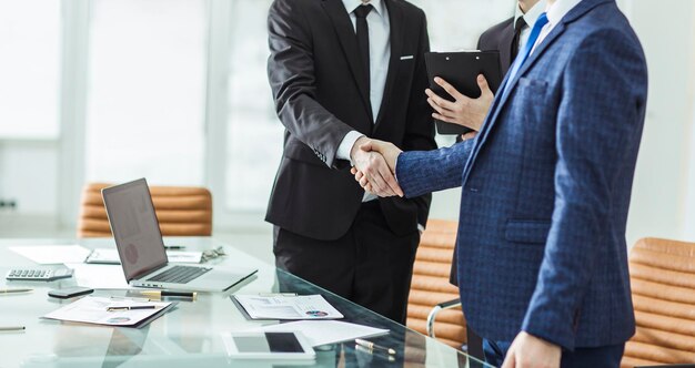現代のオフィスの握手マネージャーと顧客