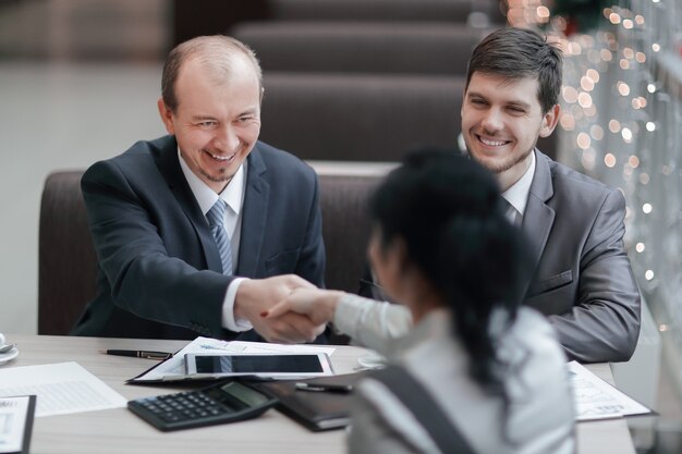 Handshake Manager en klant in een modern kantoor. Vergaderingen en samenwerkingen.