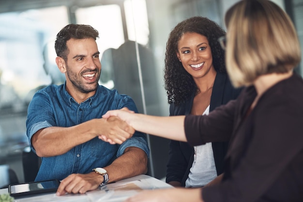 ビジネスマンの同僚や同僚による握手とチームワークは、会議での話し合いや職場での交渉で、企業の専門家が挨拶し、オフィスの会議室で協力する