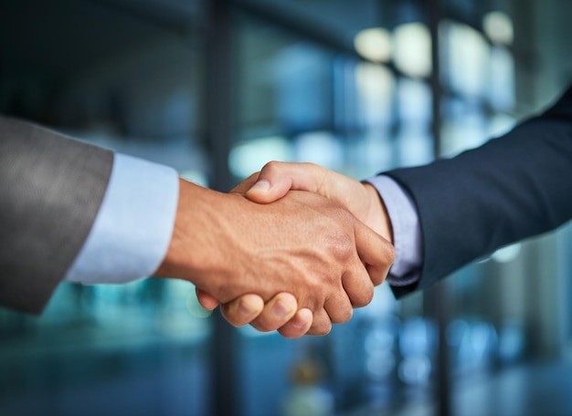 Handshake and teamwork with hands of two corporate and professional business colleagues or coworkers An agreement deal or partnership between merging companies to unite together and achieve success