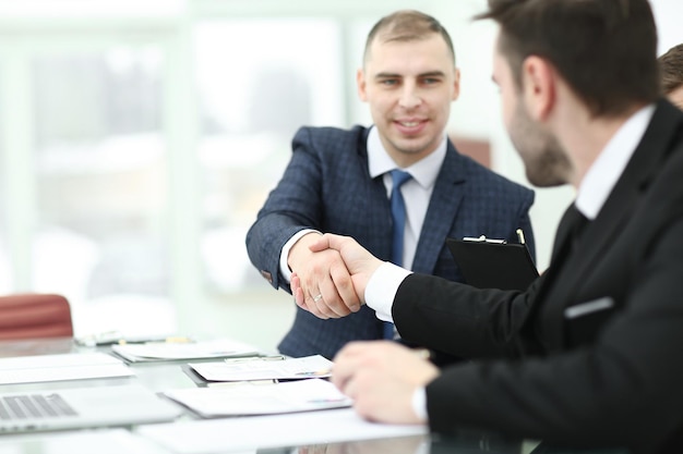 Handshake trading partners at the Desk in the office