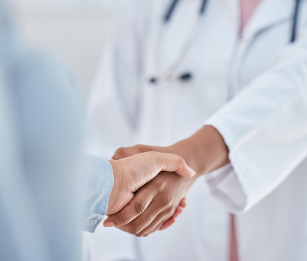 Рукопожатие, доверие и благодарность пациенту и врачу или медицинскому работнику, пожимающие друг другу руки, приветствие или знакомство во время консультации.