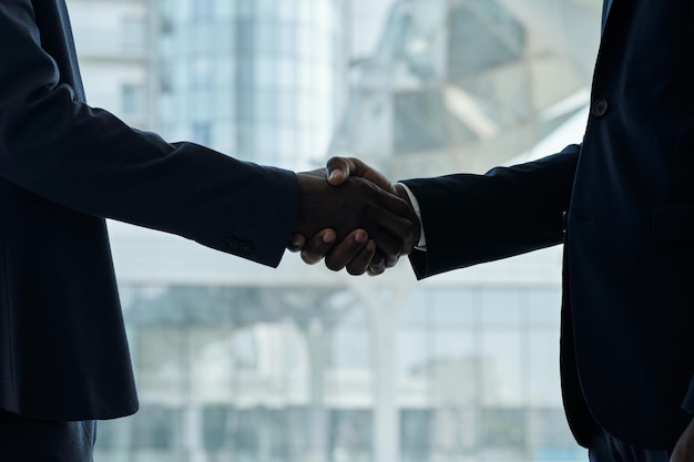 Handshake of two young african american businessmen in formalwear